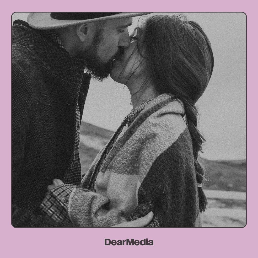 A young couple kissing outside