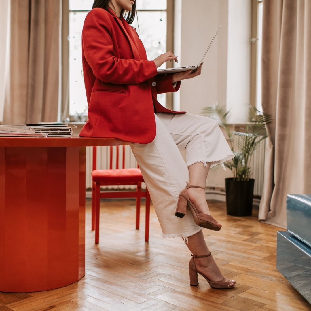 girl sitting on the table while holding her laptop