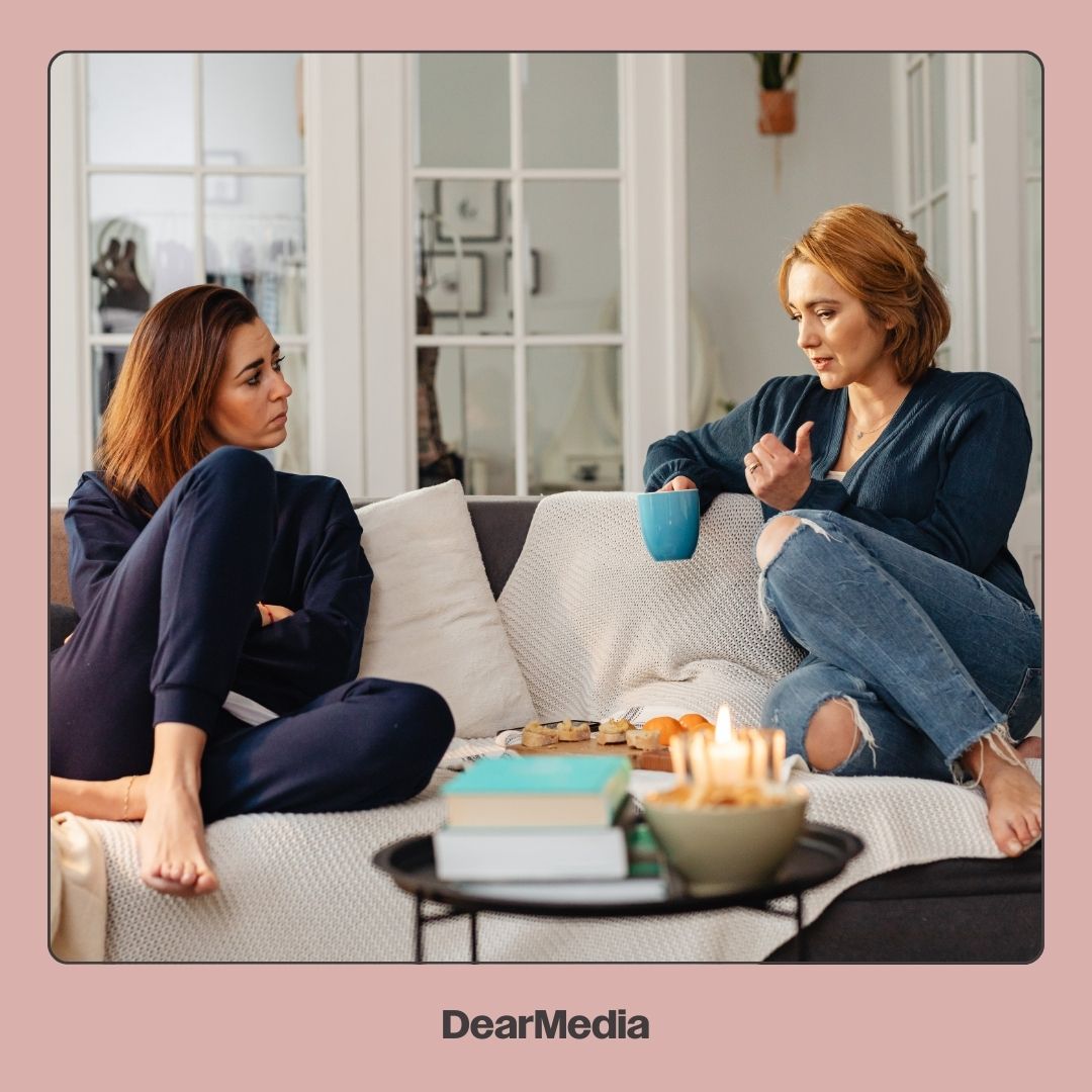 Two women having a deep conversation on a couch 