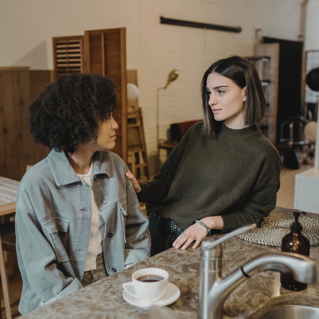 Two friends having an intimidate conversation at a coffee shop