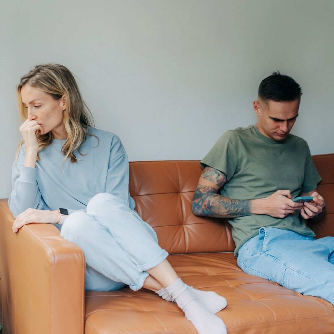 Couple sitting on the couch tense